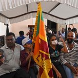 Mit einer sri-lankanischen Flagge haben sich Demonstranten auf ein Bett gesetzt