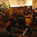 Eine Frau begleitet den Protest musikalisch auf einem Piano, während sie bejubelt wird