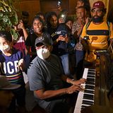 Ein Mann posiert an einem Piano