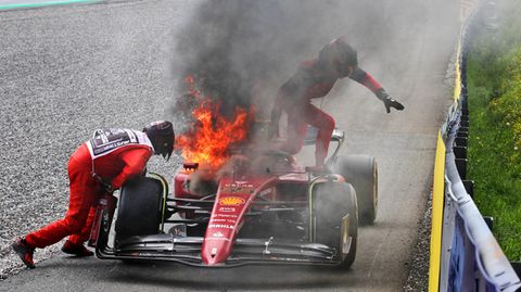 Formel-1-Rennfahrer Carlos Sainz steigt aus seinem brennenden Ferrari aus