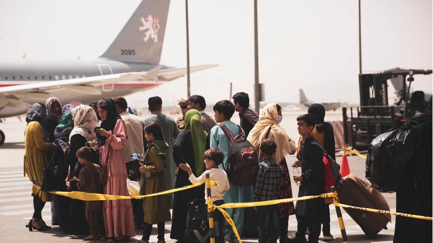 Afghanische Zivilisten warten am Flughafen in Kabul darauf, ein Flugzeug zur Evakuierung zu besteigen