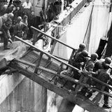 Britische Soldaten tragen einen Geflüchteten zurück auf das Hamburger Dock.