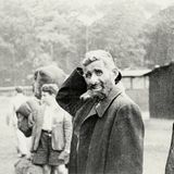 Ein geflüchteter Mann steht ratlos mit anderen Flüchtlingen zusammen.