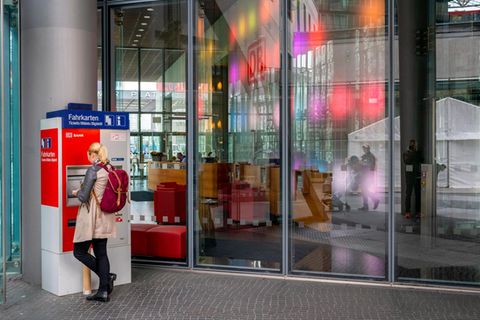 Frau an einem Fahrkartenautomat der Deutschen Bahn: Was folgt auf das 9-Euro-Ticket?