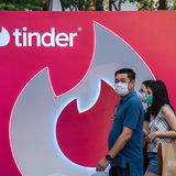 Passanten vor einem riesigen Tinder-Aufsteller in Thailand