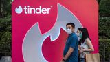 Passanten vor einem riesigen Tinder-Aufsteller in Thailand