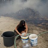 Eine junge Frau füllt Wasser in Eimer