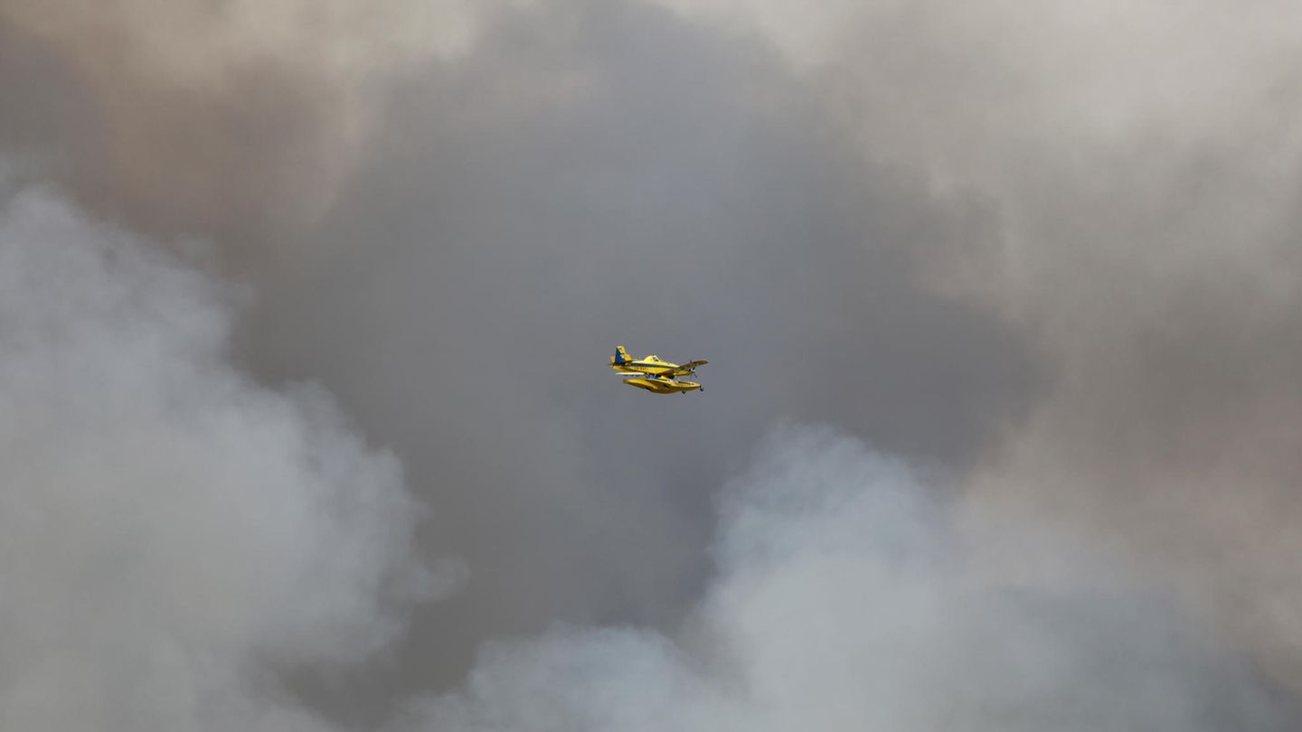 Löschflugzeug fliegt durch den Rauch