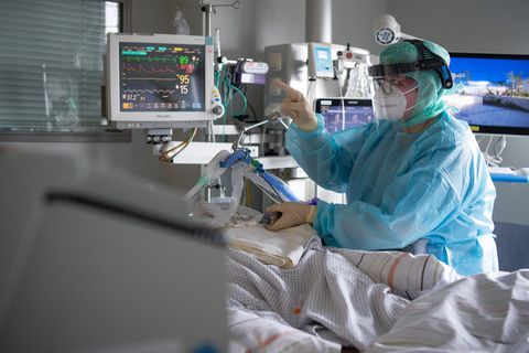 Eine Intensiv-Pflegerin versorgt einen schwer an Corona erkrankten Patienten auf der Intensivstation