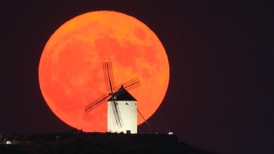  Der Supermond geht hinter einer beleuchteten Windmühle in Consuegra, Spanien, auf.