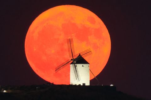  Der Supermond geht hinter einer beleuchteten Windmühle in Consuegra, Spanien, auf.