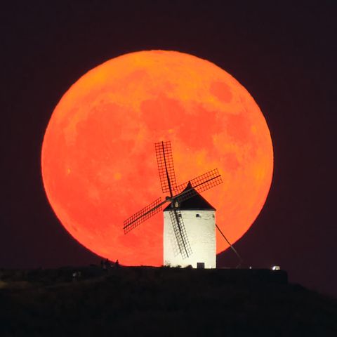  Der Supermond geht hinter einer beleuchteten Windmühle in Consuegra, Spanien, auf.