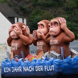 Zwölf Monate nach der Katastrophe: Ein bitterer Gruß an Politik, Bürokratie, Versicherungen und auch Bundeskanzler Olaf Scholz, der sich zum Jahrestag im Katastrophengebiet hat blicken lassen. Die Hilfe kommt viel zu langsam an, bemängeln die Betroffenen. Der Motivwagen am Ortseingang von Dernau wurde vom legendären Wagenbauer des Düsseldorfer Rosenmontagszuges, Jacques Tilly, entworfen.