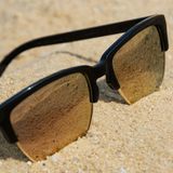 Eine Sonnenbrille liegt im Sand