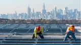 Elektriker in New York installieren Solarzellen auf einem Dach