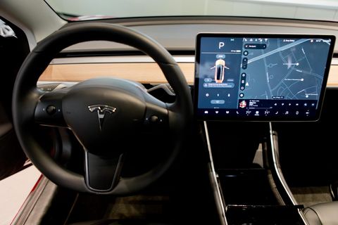 Das Fahrercockpit eines Tesla Model 3 mit einem zentralen Touchscreen