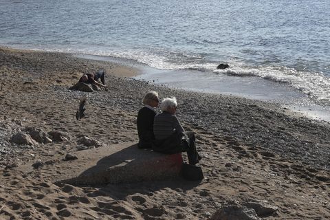 Menschen sitzen an einem Strand