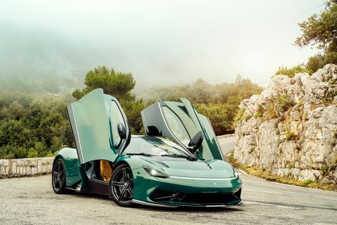 Der Pininfarina Battista steht mit geöffneten Flügeltüren auf einer Straße