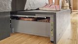 Bitte betreten!  Der Space-Step der österreichischen Herstellers Blum ist eine kongeniale Idee. Er verwandelt die Sockelschublade in einen stabilen Tritt, ohne das die Schublade ihre eigentliche Funktion verliert. Praktisch für Kinder, die beim Kochen mithelfen wollen, aber auch für Senioren zum Erreichen der Oberschränke.