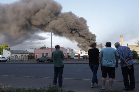 Menschen beobachten eine Rauchwolke nach einem Raketenangriff in Odessa