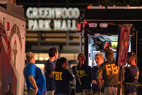 Vor einer Mall stehen Männer und Frauen in "FBI"-T-Shirts hinter einem von innen beleuchteten Kastenwagen