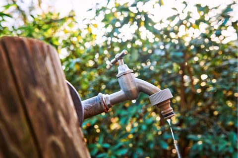 Wasser fließt in kleinen Tropfen aus einem Wasserhahn
