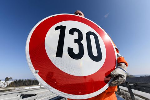 Ein Straßenwärter hält an der Autobahn A81 am Hegaublick ein Schild mit der Aufschrift «130» in den Händen