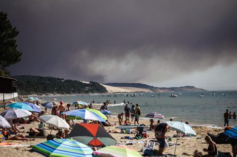 Hitzewelle in Frankreich: Dunkle Wolken über einem Strand durch einen Waldbrand