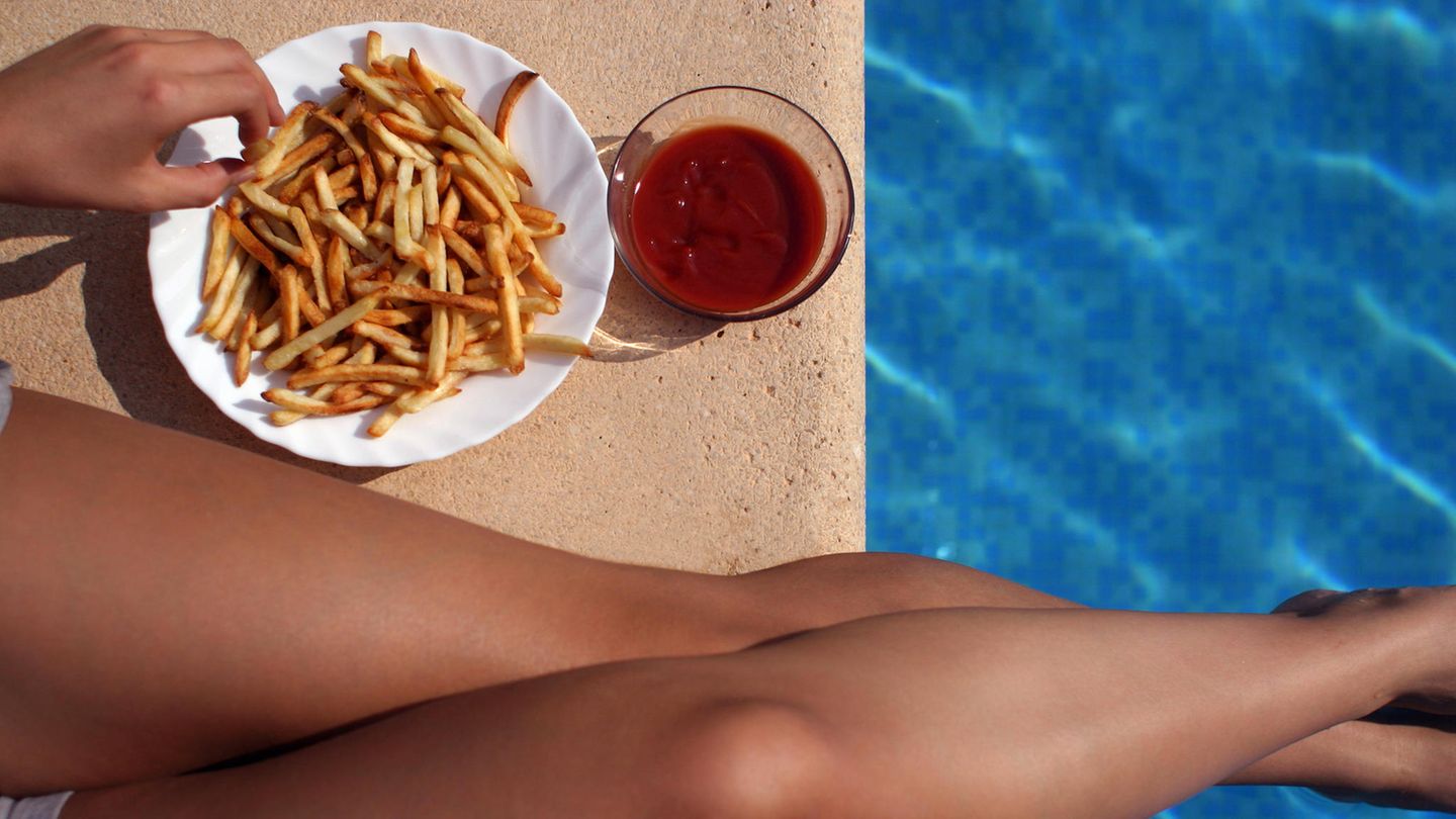 Eine Frau ist im Schwimmbad Pommes