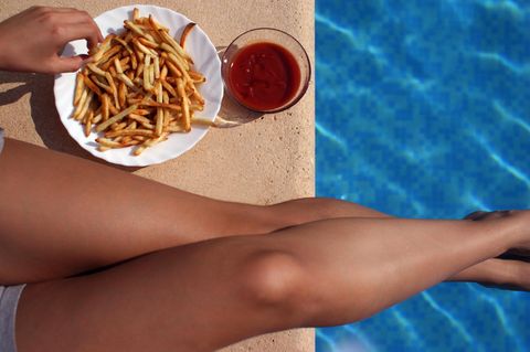 Eine Frau ist im Schwimmbad Pommes