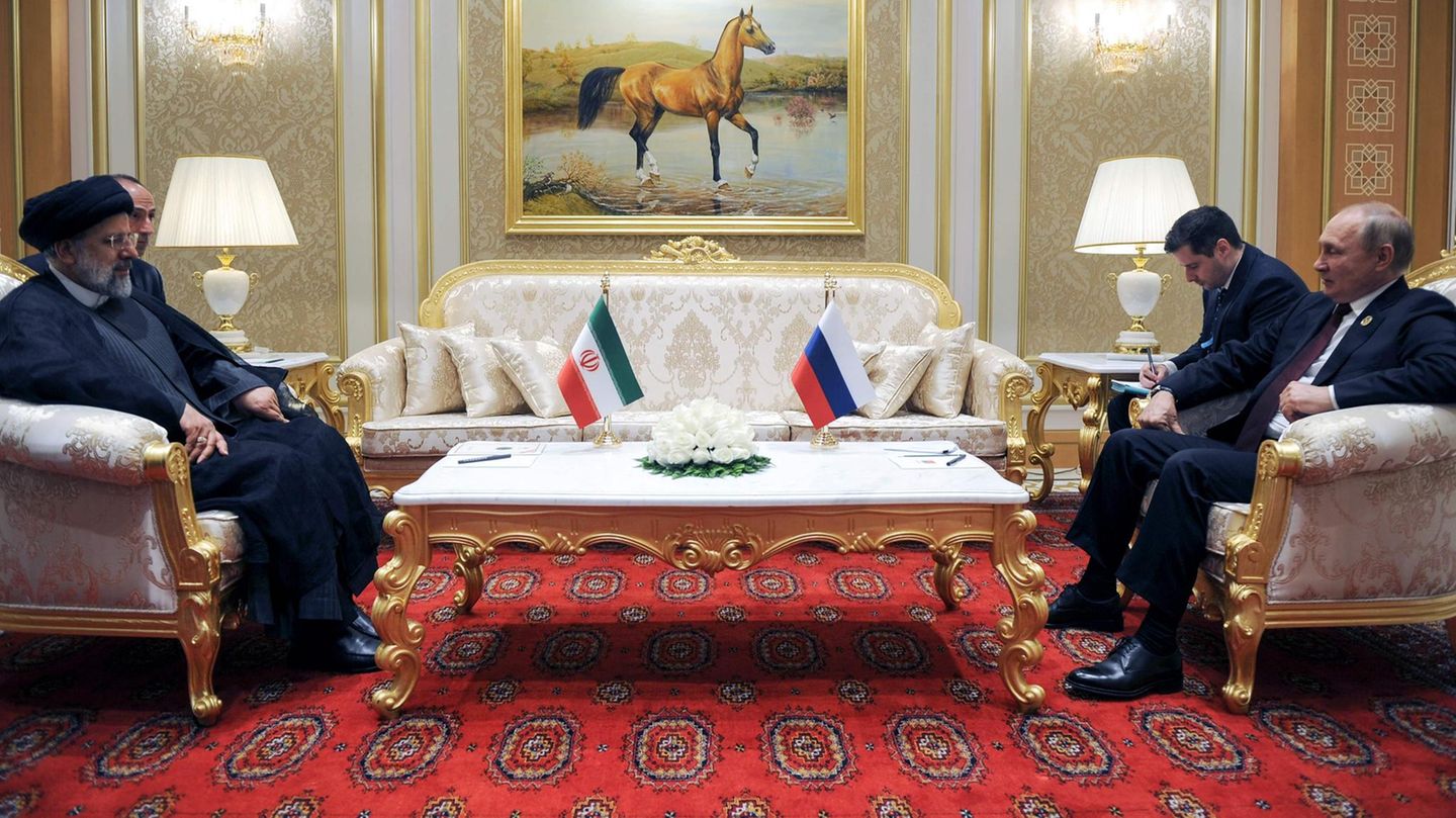 Wladimir Putin (r) spricht mit dem iranischen Präsidenten Ebrahim Raisi