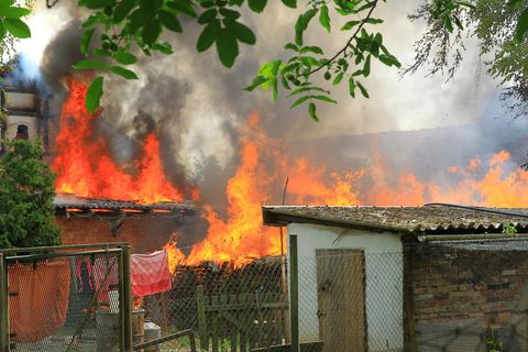 Ein Haus und Nebengebäude stehen bei einem Brand in Flammen