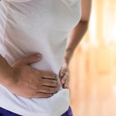 Eine Person hält sich das Becken aufgrund von Schmerzen