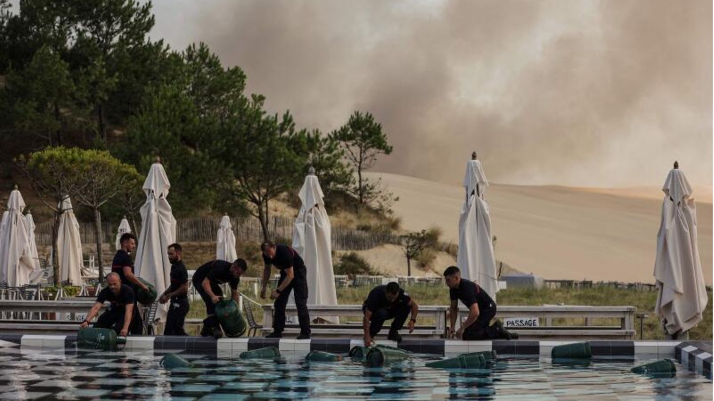 Pyla-sur-Mere, Frankreich. Zum Schutz vor der Hitze verstauen Feuerwehrleute Gasflaschen im Swimmingpool