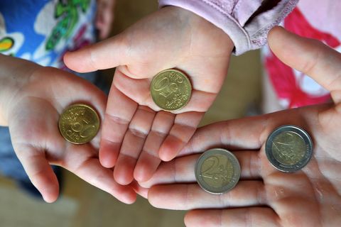 Kindergeld: Drei Kinderhände halten Euro-Münzen in ihren offenen Händen