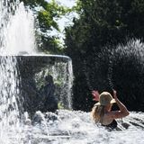 Diese Frau kühlt sich am Albertplatz in Dresden, Sachsen,  in den Wasserfontänen der Brunnen "Stilles Wasser" und "Stürmische Wogen" ab