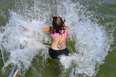 Ein Mädchen stürzt sich über eine Wasserrutsche in den Storkower See in Brandenburg