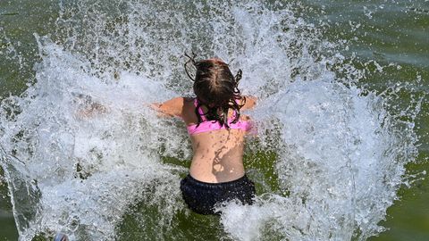 Ein Mädchen stürzt sich über eine Wasserrutsche in den Storkower See in Brandenburg