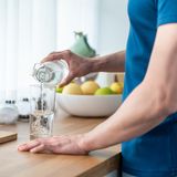 Mann gießt sich Wasser ein