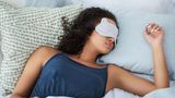Frau liegt mit Schlafmaske im Bett