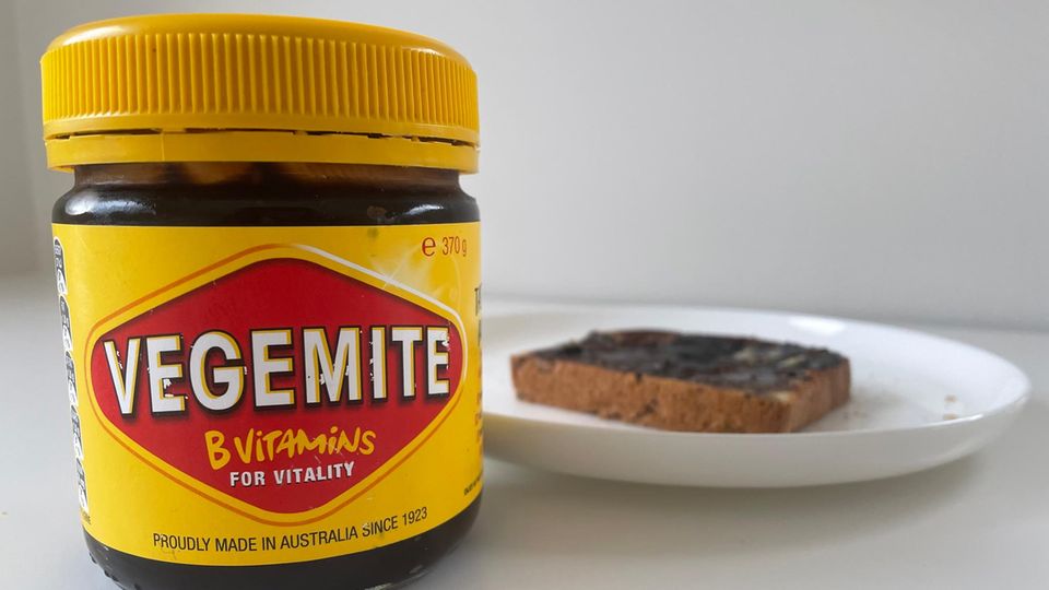 Vegemite Australien Ein Glas Vegemite steht neben einem Teller mit Toastbrot
