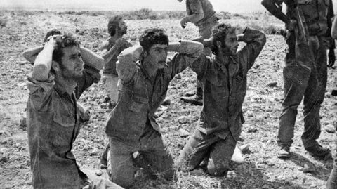 Soldaten halten ihre Hände auf den Hinterkopf und knien auf dem Boden
