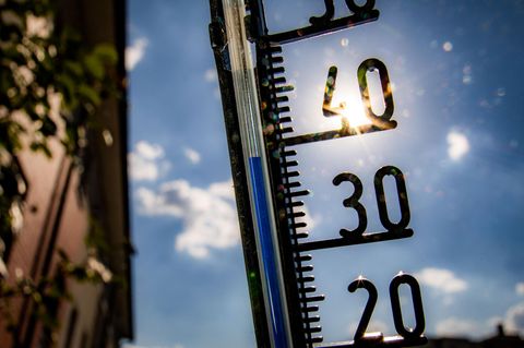 Ein Thermometer an einer Hauswand klettert in Richtung der 40-Grad-Marke (Archivfoto)