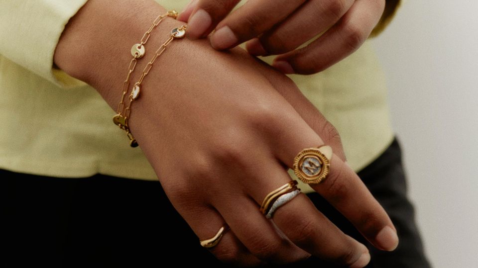 Person trägt auffällige Ringe in Gold und Silber und ein Armband in Gold - passend zu den Schmuck-Trends 2023
