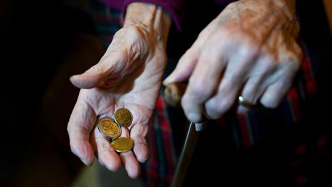 In den Händen einer alten Frau liegt Kleingeld