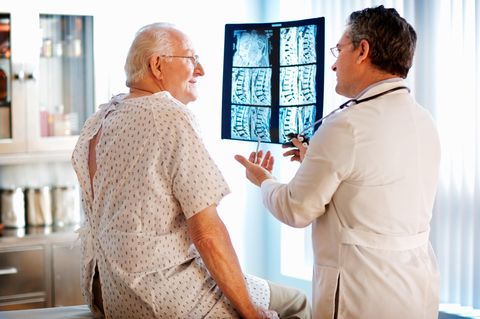 Wirbelsäulenchirurg zeigt Röntgenbilder seines Patienten