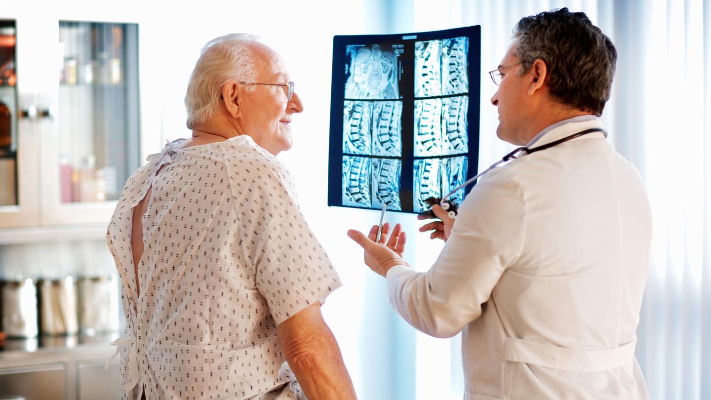 Wirbelsäulenchirurg zeigt Röntgenbilder seines Patienten