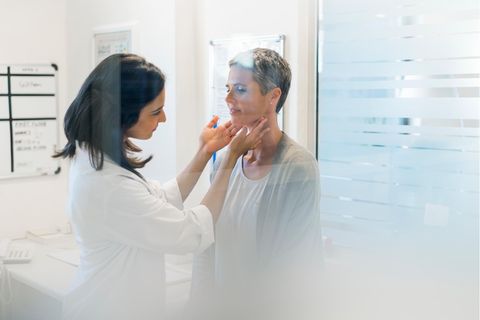 Eine Ärztin tastet die Schilddrüse einer Patientin ab