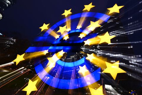 Die Euro-Skulptur des Künstlers Ottmar Hörl leuchtet am Abend vor den Bankentürmen