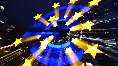 Die Euro-Skulptur des Künstlers Ottmar Hörl leuchtet am Abend vor den Bankentürmen